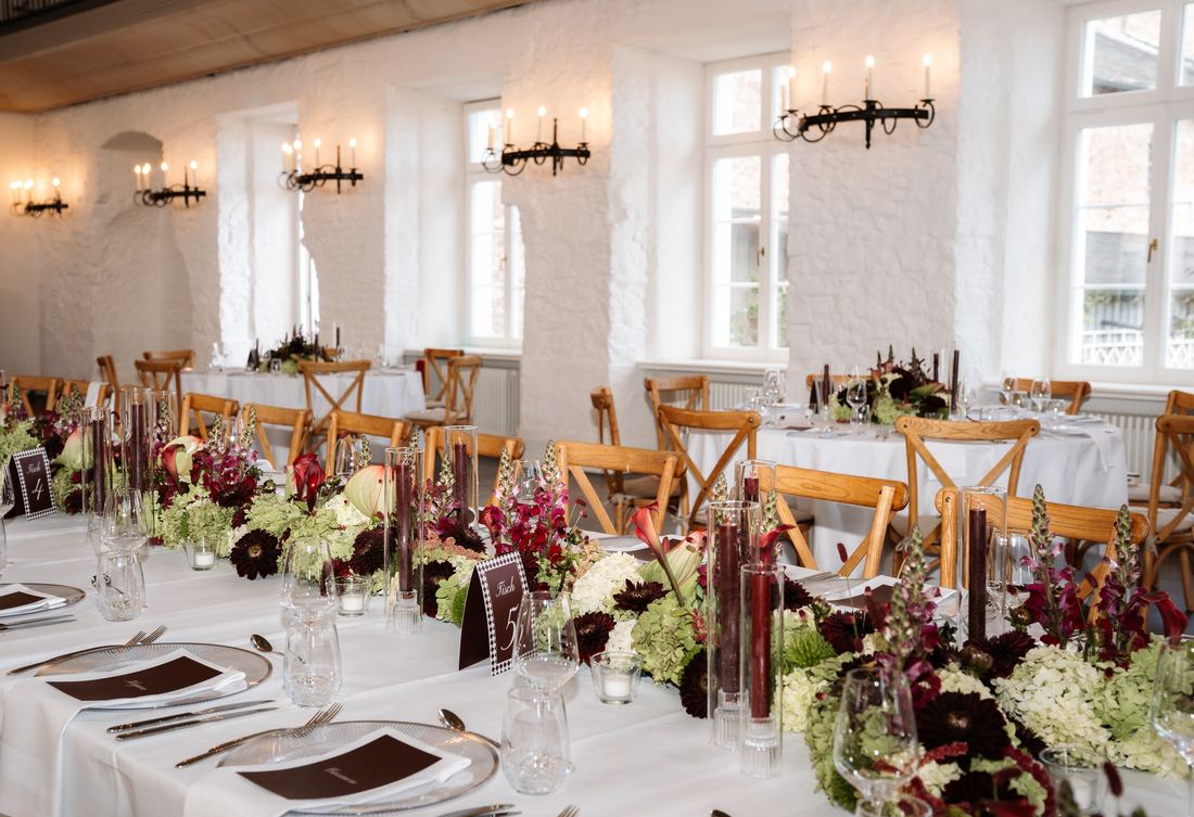 Festlich gedeckte Tafel mit Bordeaux-Blumen