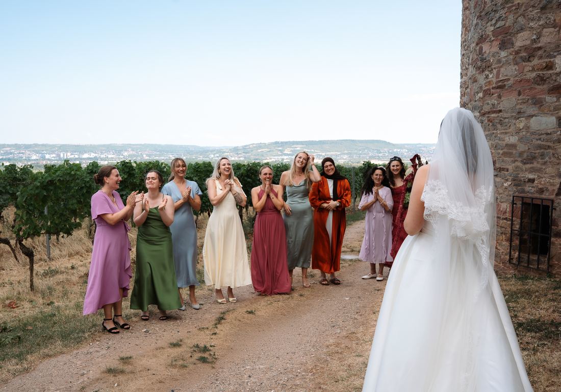 Brautjungfern und Familie empfangen die Braut beim First Look